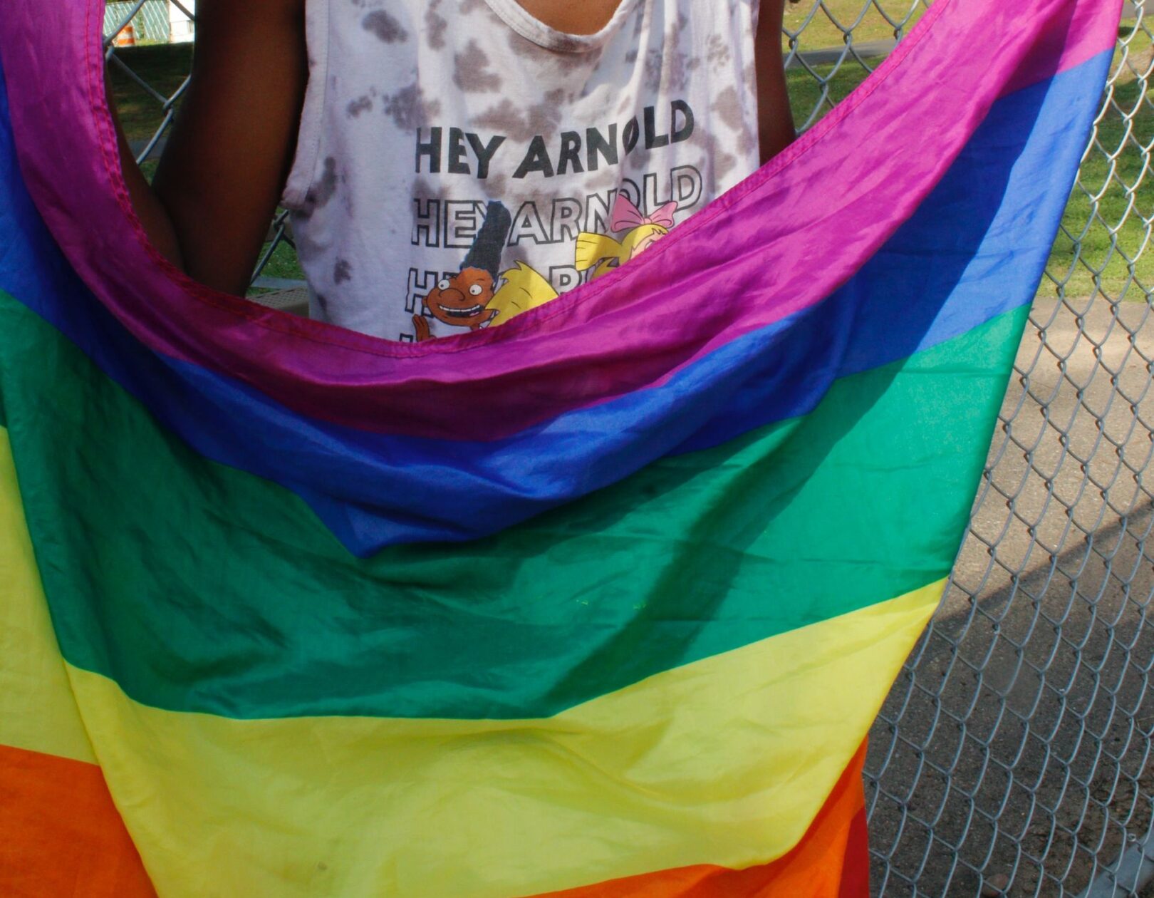 A boy holding a rainbow flag.