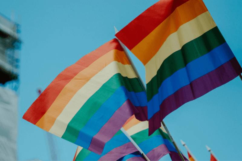 Rainbow flags flying in front of a construction site.