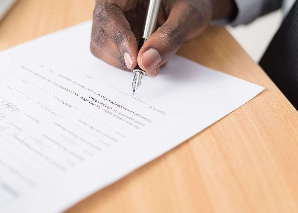 A man signing an open letter with a pen.