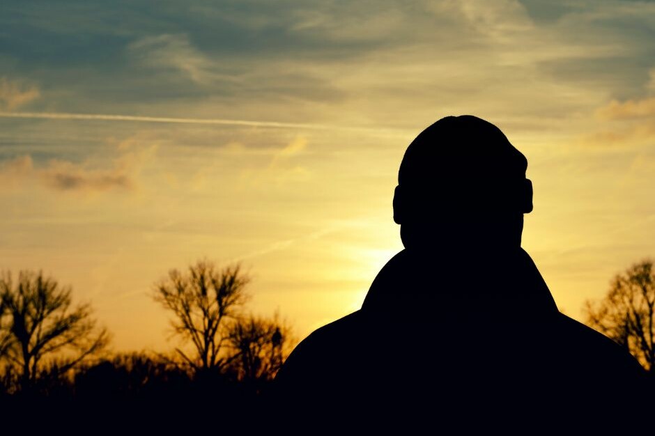A silhouette of a person in front of a sunset.