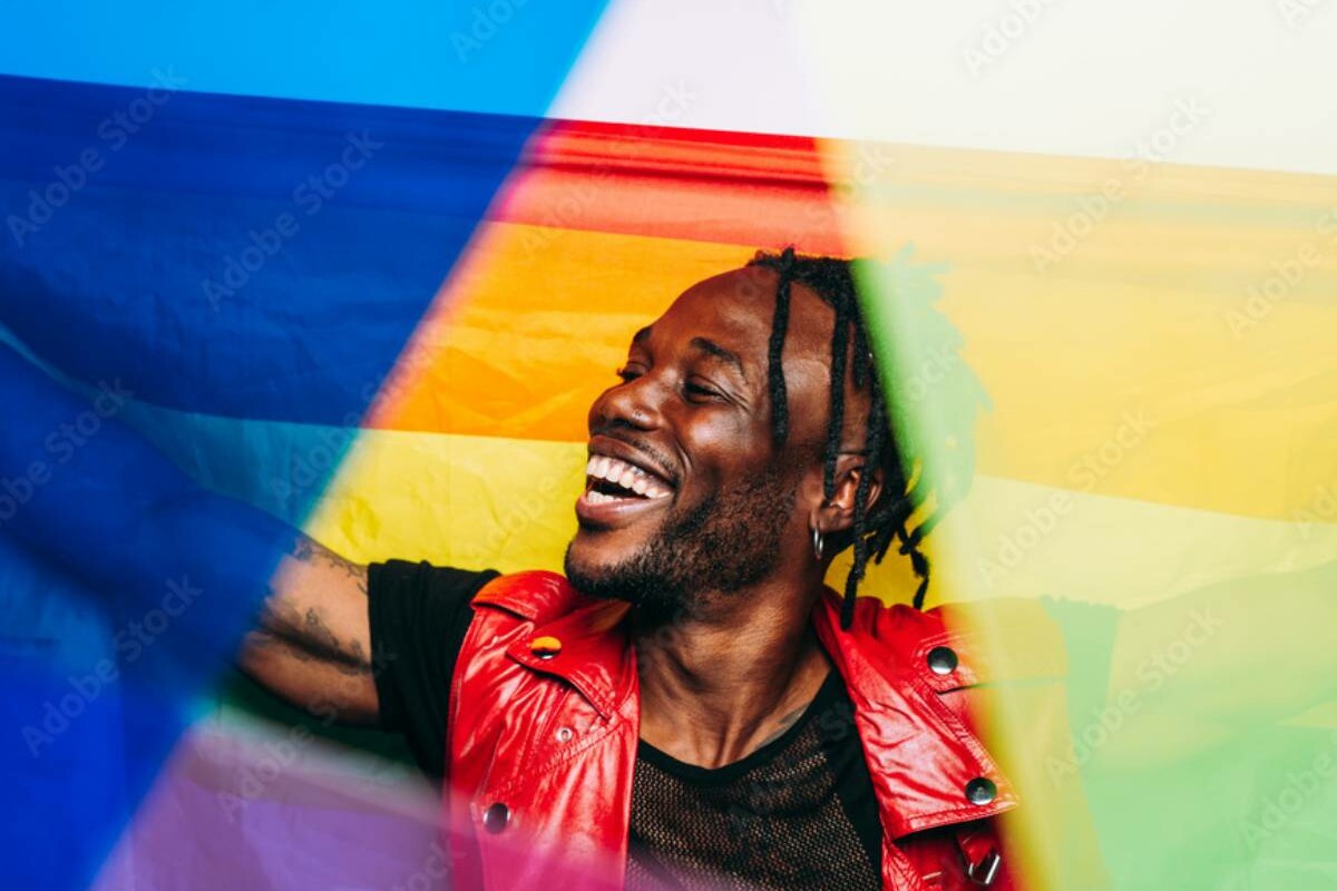 person smiling with rainbow flag