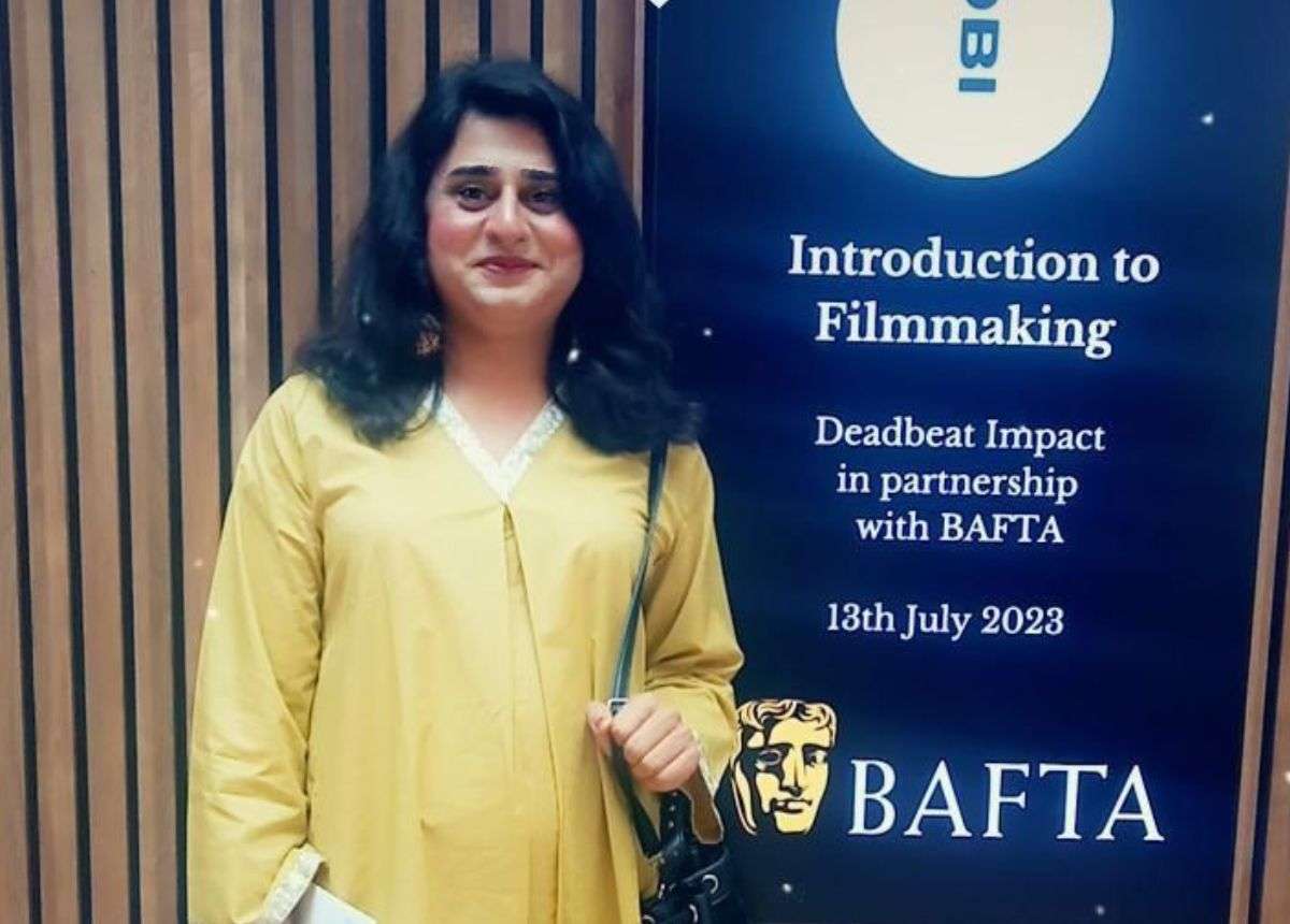 A woman standing in front of a bafta sign.