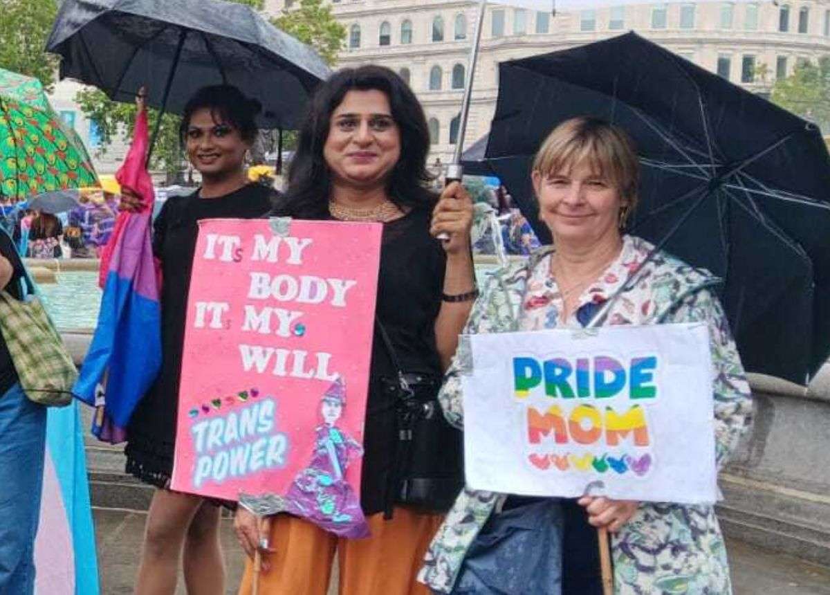A group of women holding signs and umbrellas.