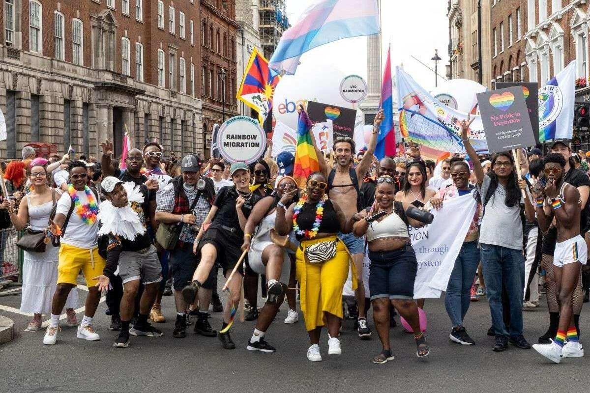 A group of people holding pride flags on a street.