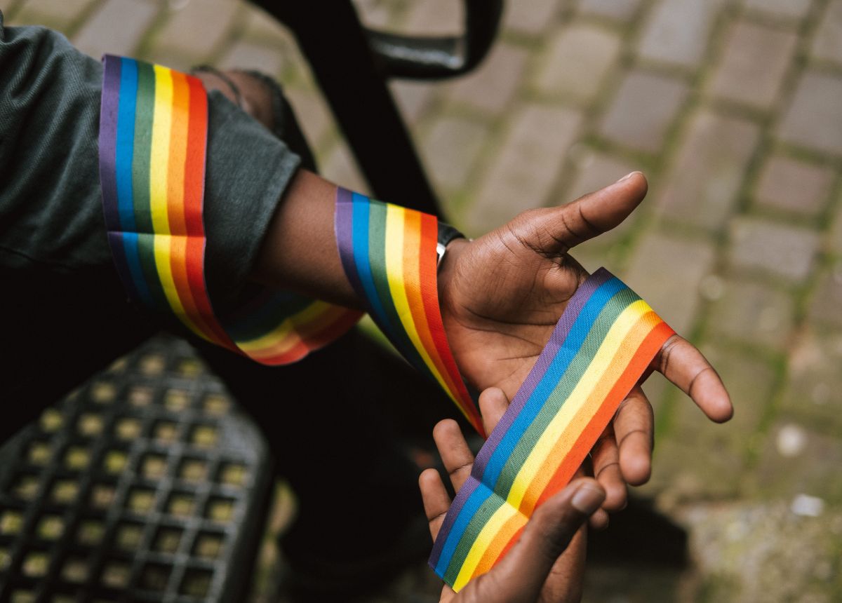 Black man wearing LGBT ribbon around arm. Photo by Anete Lusina