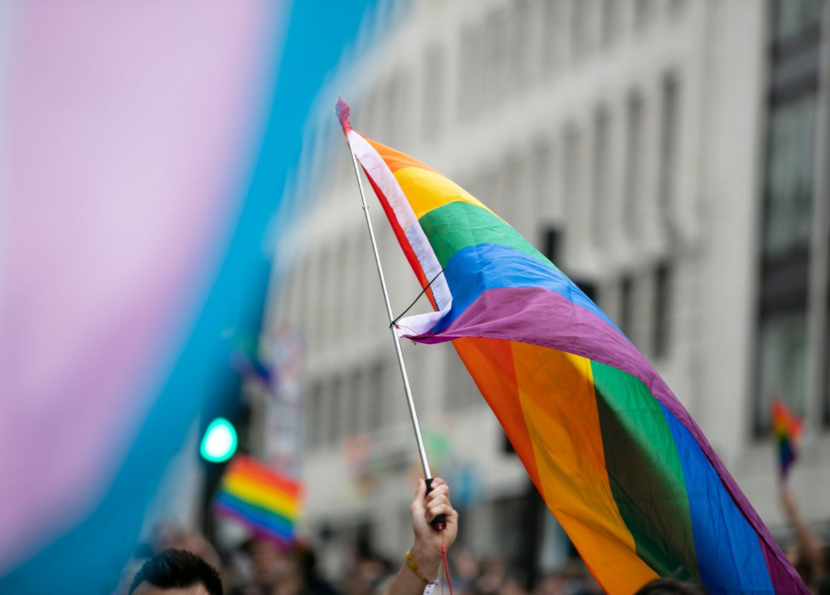 A hand waving LGBT flag